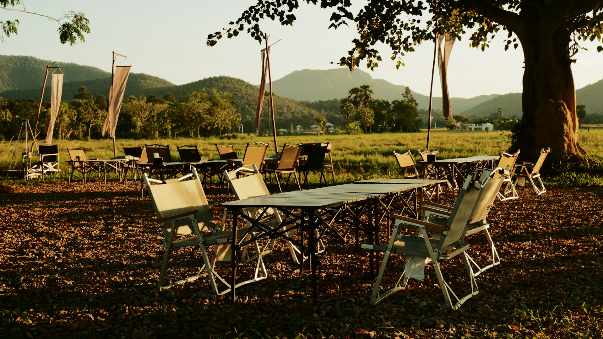 Tables and chairs are set up in a field.